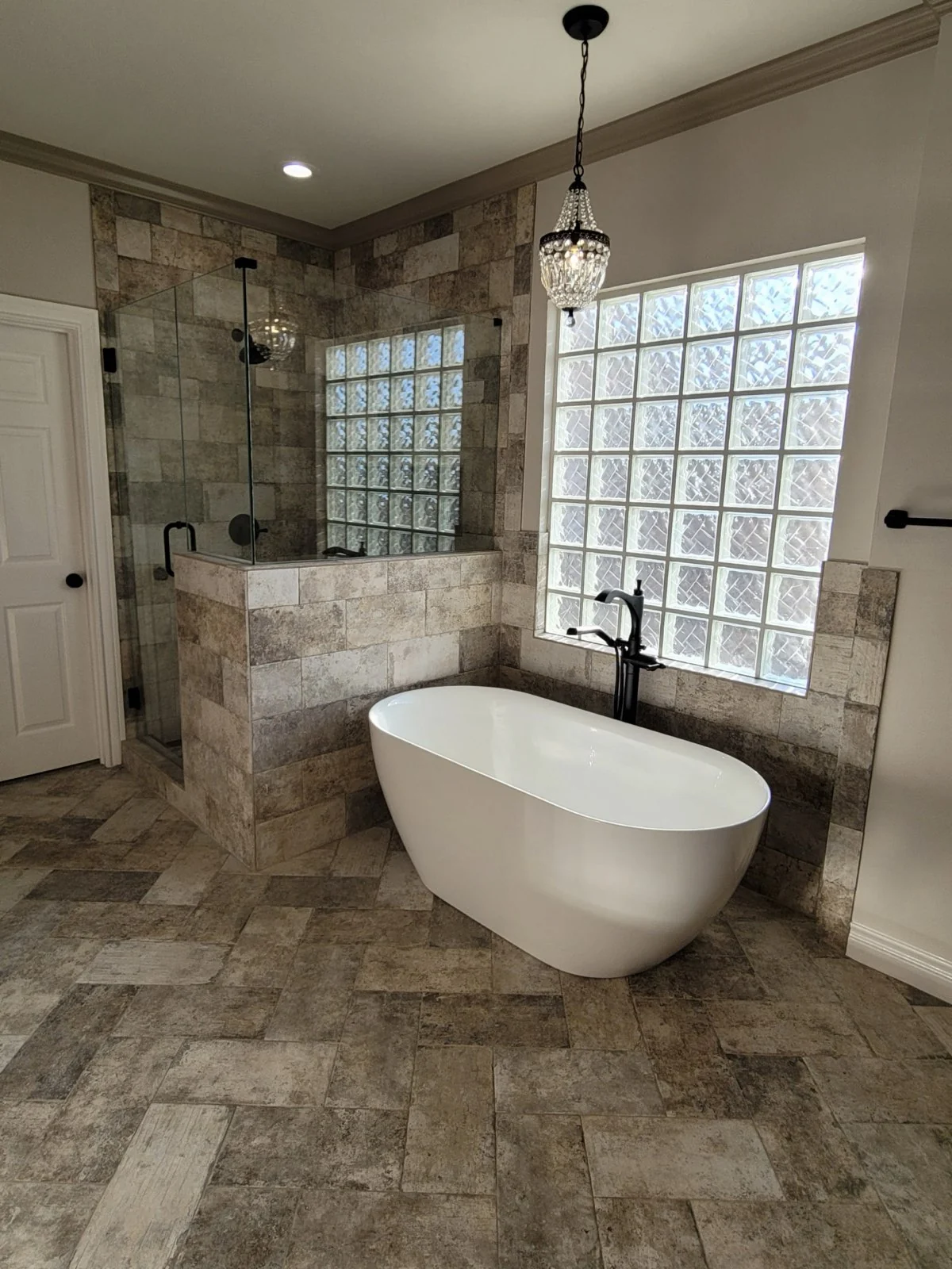 Bathroom remodel with freestanding tub, glass shower and stone-look tile in Missouri City