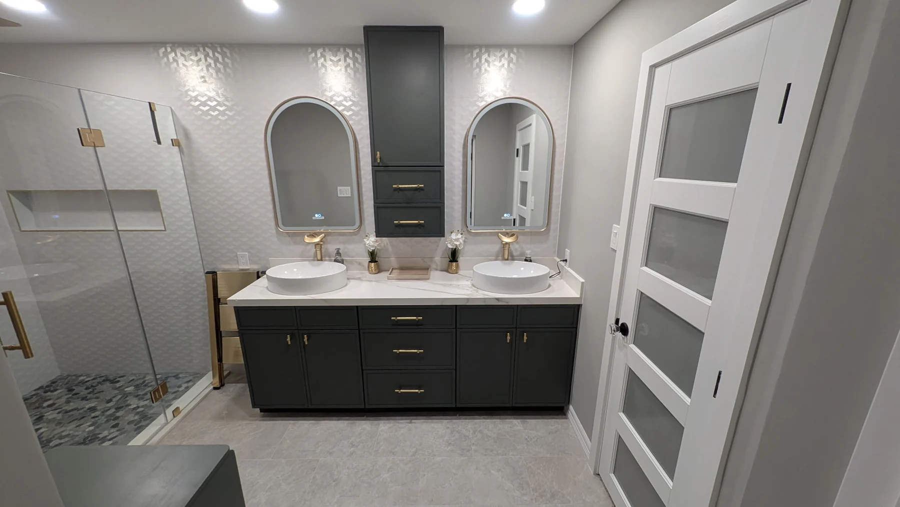 Modern bathroom remodel with double vanity, vessel sinks, gold fixtures and glass shower