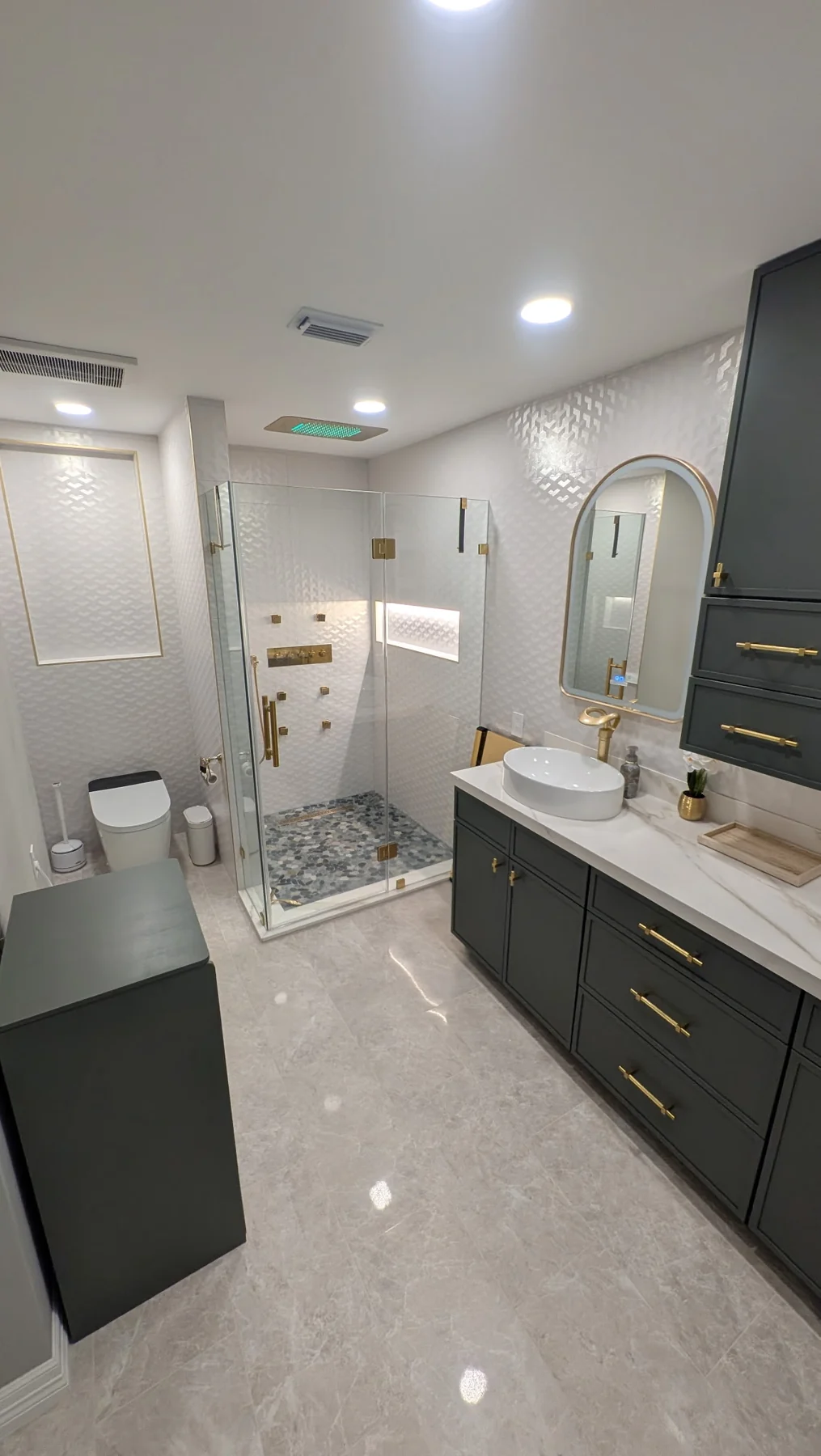 Bathroom renovation with walk-in shower, vessel sink vanity, gold fixtures and polished tile floor