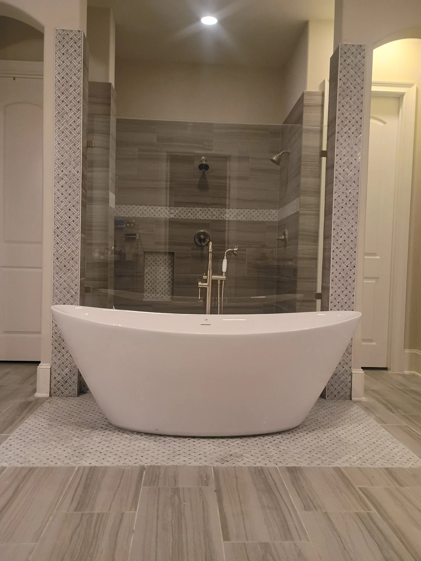 Bathroom remodel with freestanding tub, glass feature shower and decorative tile accents