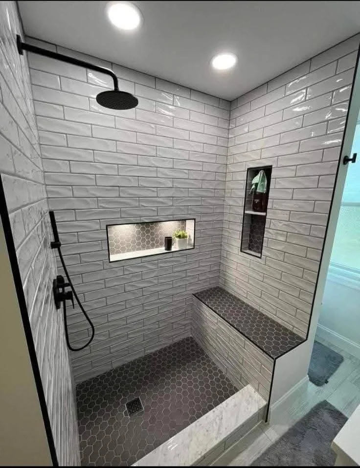 Custom walk-in shower with bench, niches, black fixtures and hex mosaic floor