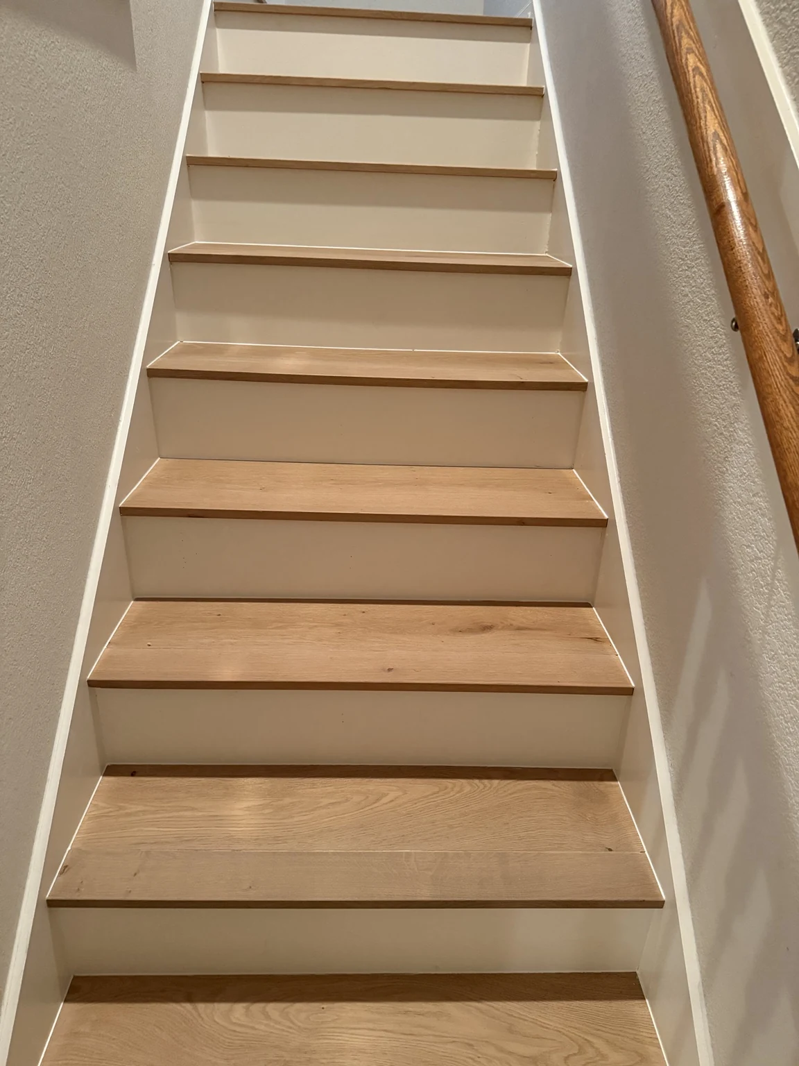 Straight staircase with engineered hardwood stair treads and white risers