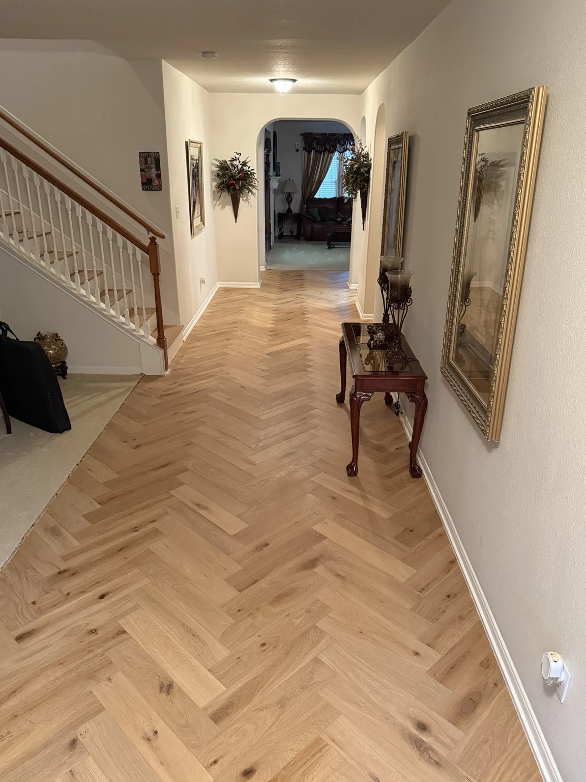 Herringbone engineered hardwood flooring in a long hallway