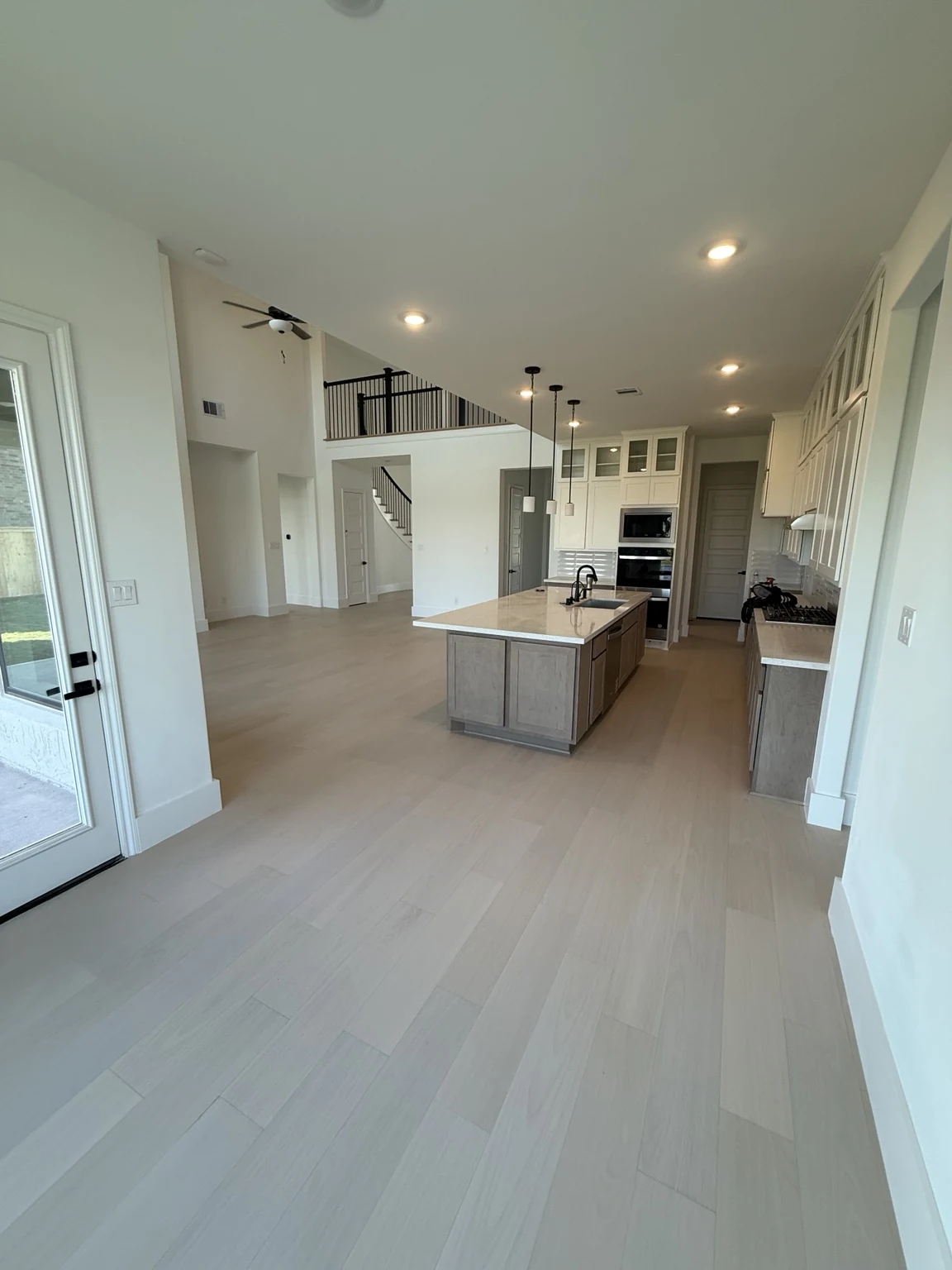 Open kitchen and living space with light engineered hardwood flooring