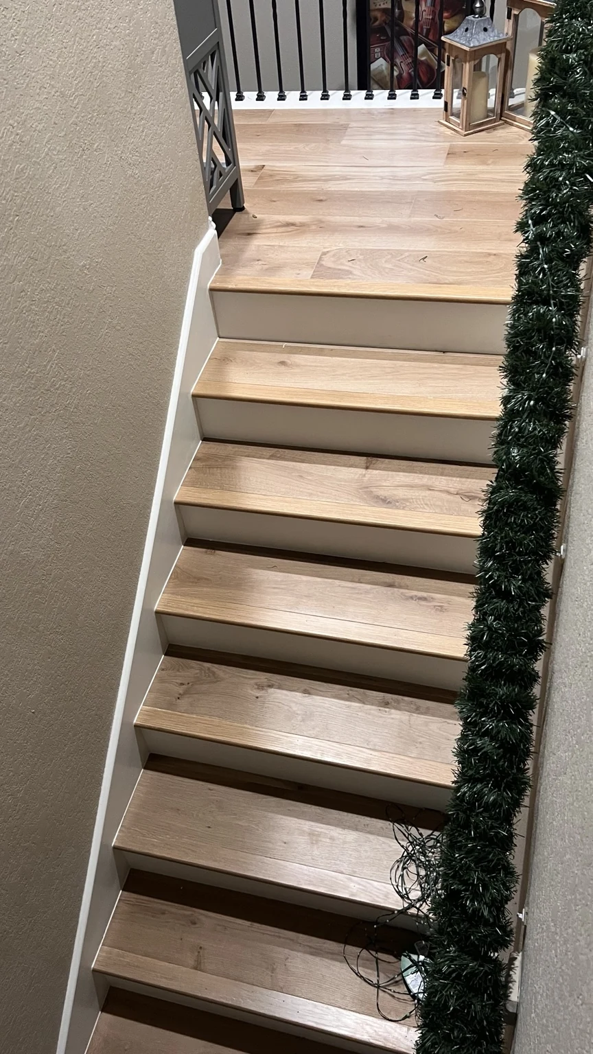 Engineered hardwood stairs with white risers and black balusters