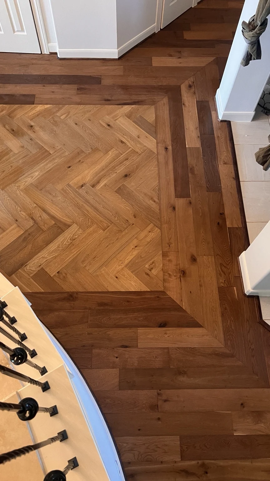 Herringbone engineered hardwood flooring with a decorative perimeter border