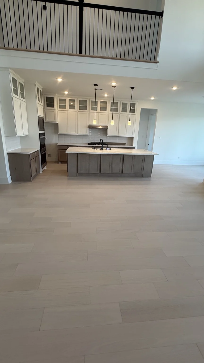 Two-tone kitchen with light floors and island