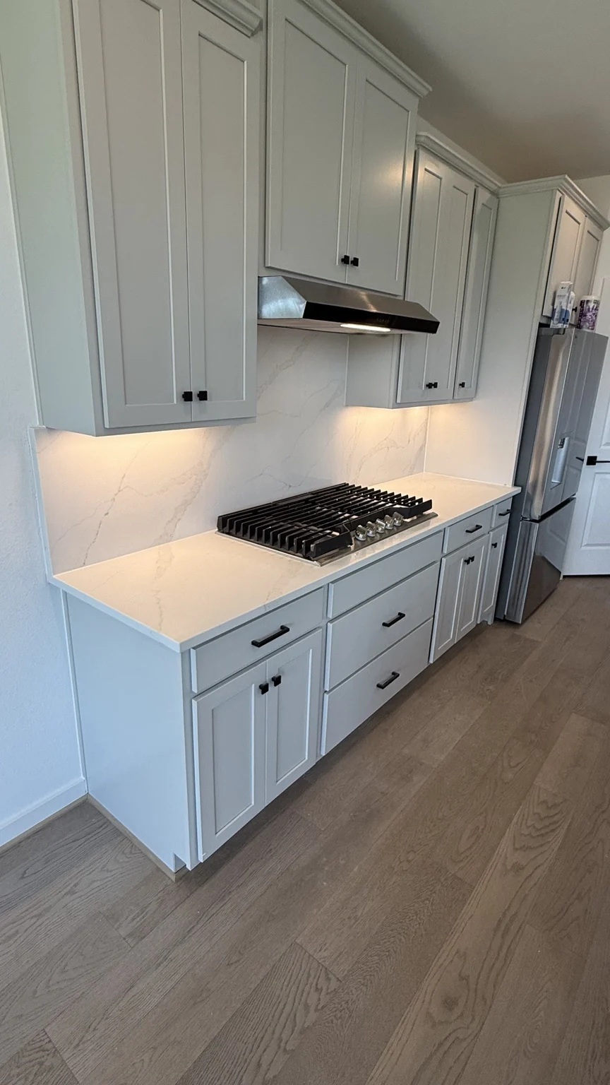 Light kitchen cabinets and stone backsplash