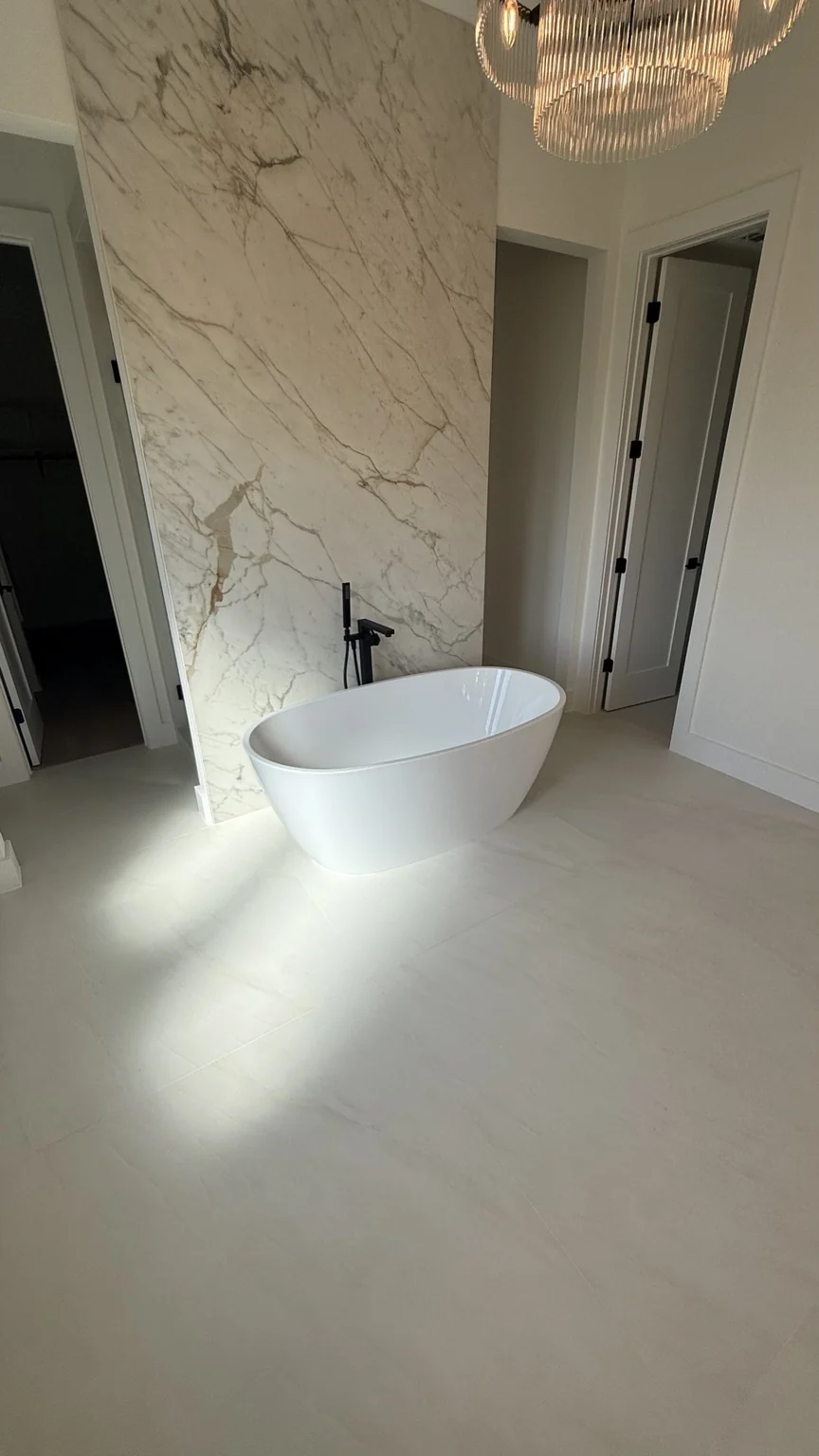 Freestanding bathtub with light marble-look floor tile
