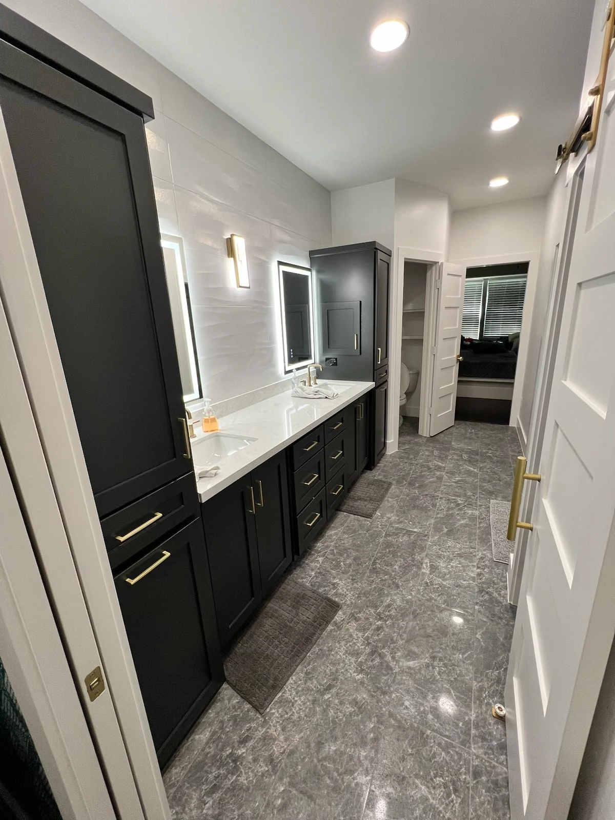 Dark bathroom cabinets over gray stone-look tile floor