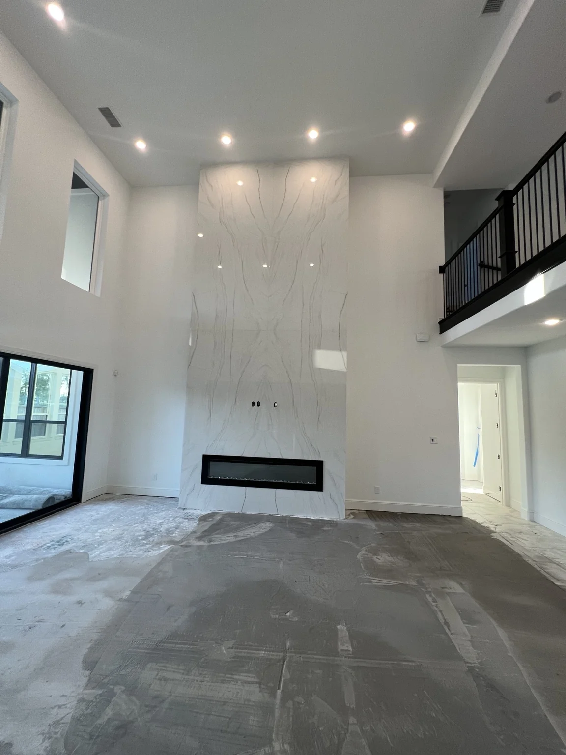 Tall living room fireplace feature wall with large-format white tile