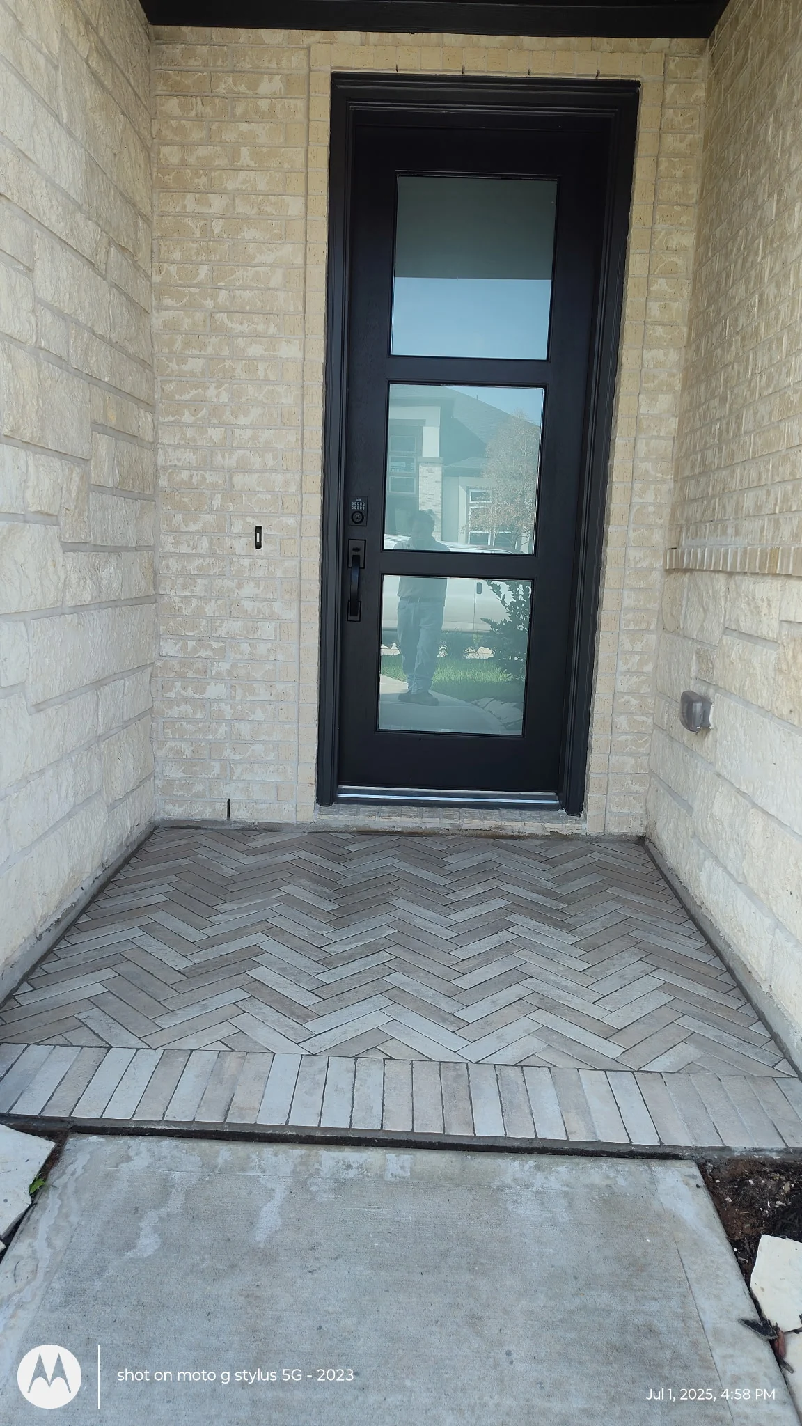 Outdoor entry floor featuring gray herringbone tile
