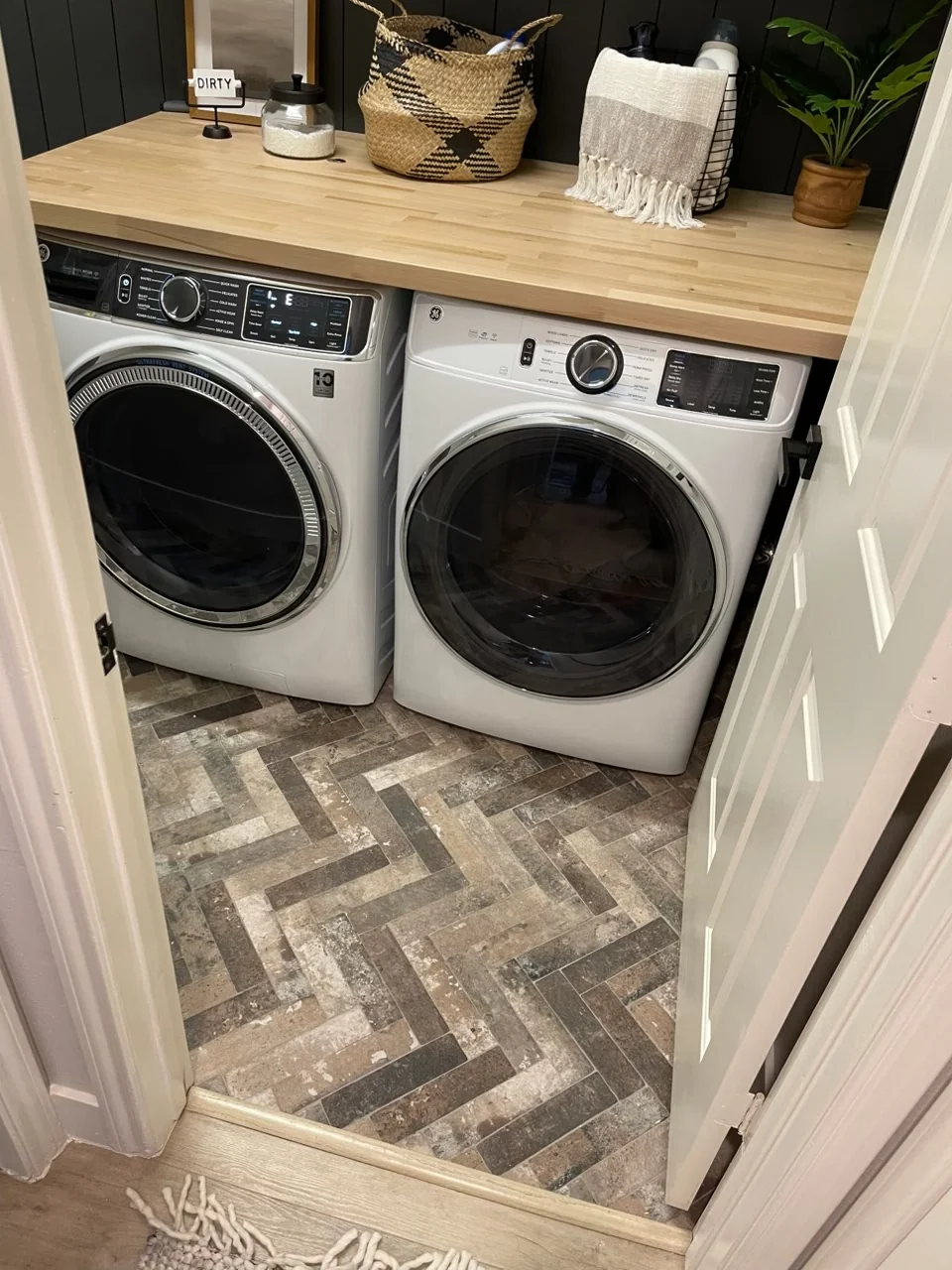 Laundry area with stone-look tile floor under washer and dryer