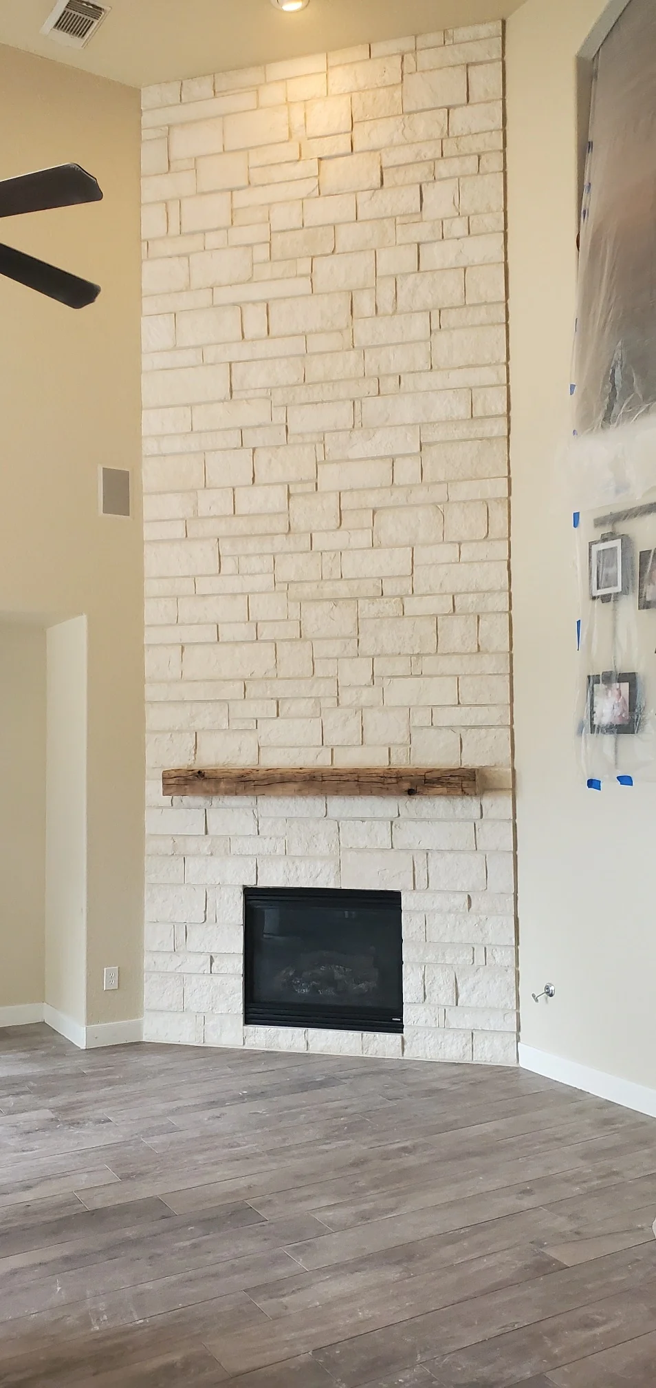 Cream brick-look tile fireplace with wooden mantel