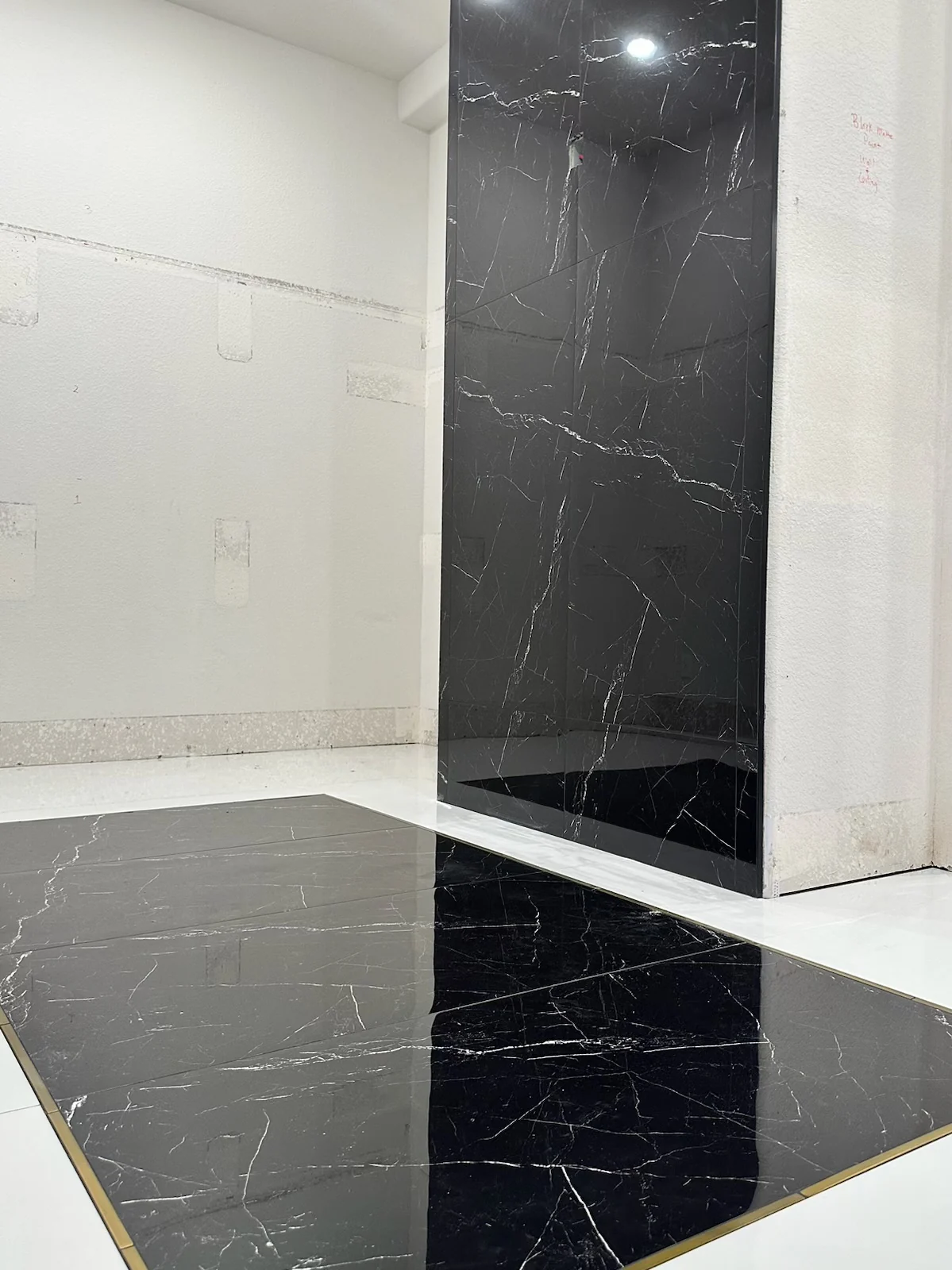 Black marble-effect tile and white tile wall detail