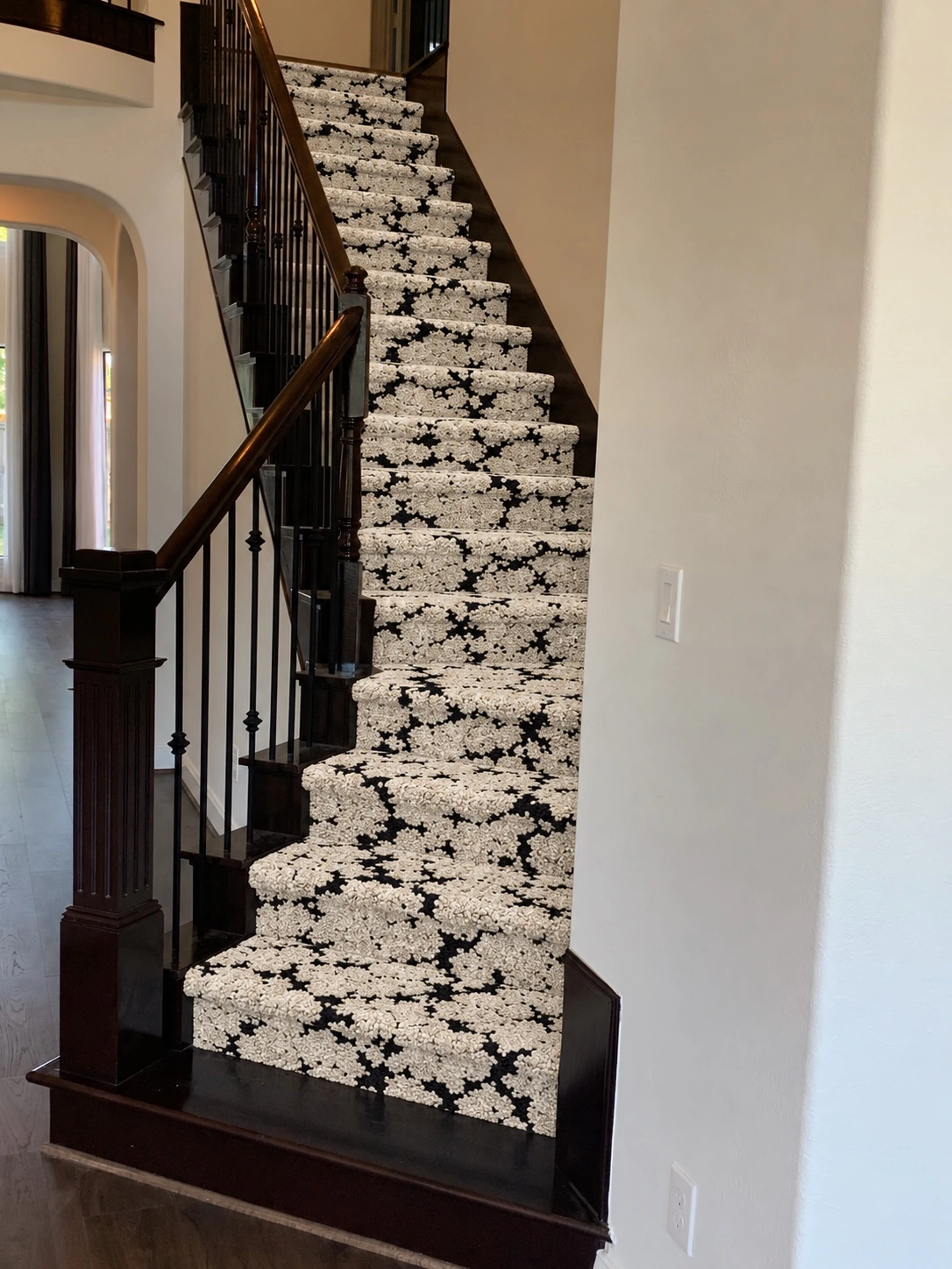 Wanderlust Oryx black and ivory carpet installed on a dark wood staircase